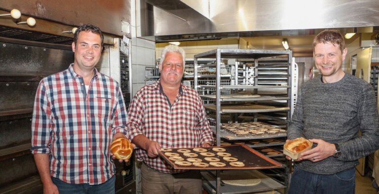 Landwirt Markus Gut, Bäcker Andreas Iten und Landwirt Andreas Mohni mit Backwaren aus Urdinkel
