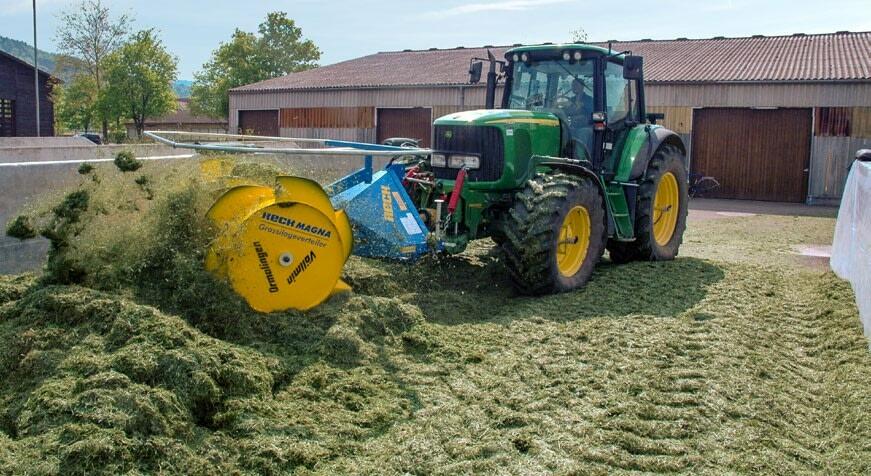 Walztraktor mit Grassilageverteiler auf dem Fahrsilo